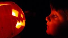 Child looking at a Halloween Pumpkin