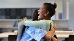 Students at the London Academy of Excellence Tottenham (LAET) embrace after receiving their A-Level results in north London on August 10, 2021.