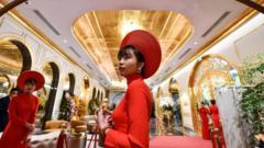 Staff wait to welcome guests in the lobby of the newly-inaugurated Hanoi Golden Lake hotel, the world"s first gold-plated hotel, in Hanoi on July 2, 2020.