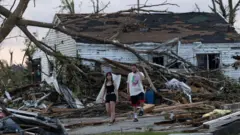 Residents survey damage after a tornado ripped through town.