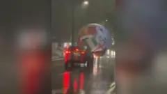 Giant World Cup football seen in front of a car in El Salvador