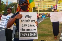 Protestors hold placards as they take part in an anti-government demonstration in Colombo on September 25, 2022. 