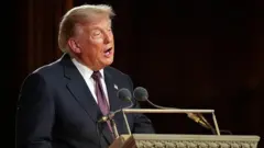 Trump delivering a speech at the lectern.