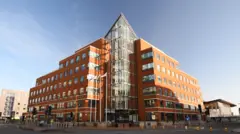 The image shows the red brickTy Hywel building on a sunny day.