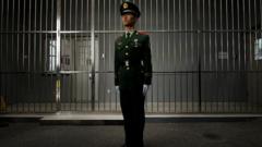 Seorang petugas berdiri di depan penjara di Beijing.