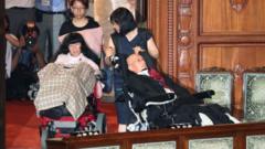 Funago ve Kimura, tekerlekli sandalyeleriyle salona girdiğinde alkışlarla karşılandı.