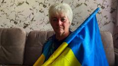 School director Lidiya Tilna sat on a sofa holding a Ukrainian flag
