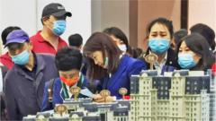 People look at models of houses at the 2021 Dalian autumn real estate fair at Dalian World Expo Centre.