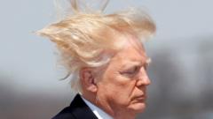US President Donald Trump boards Air Force One on a windy day in Maryland in 2018
