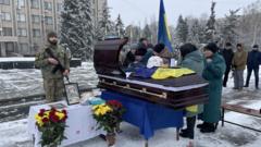 Image of people gathered around a coffin at Denys Sosnenko's funeral