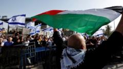 Palestinian man holds Palestinian flag opposite Israeli flags in Jerusalem (29/05/22)