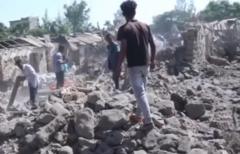 People searching through rubble from collapsed buildings