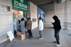 Sejumlah warga di Nanjing, China, mengantri untuk membeli obat di sebuah apotek.