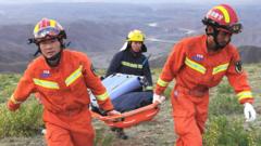 This photo taken on May 22 2021 shows rescuers carrying equipment as they search for runners who were competing in a 100-kilometre cross-country mountain race when extreme weather hit the area leaving at least 20 dead near the city of Baiyin in Chinas northwestern Gansu province