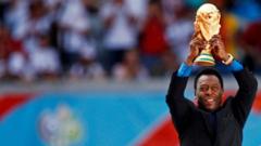 Pele holds the World Cup trophy in 2006 World Cup opening ceremony in Munich