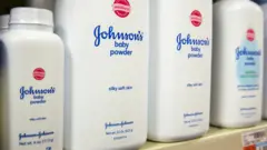 Johnson's baby powder bottles are presented on a shelf in a store in New York in 2015. The bottles have text on them reading 'silky soft skin' and 'mildness'.