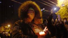 Protesters hold candles and blank white pieces of paper during a protest triggered by a fire in Urumqi that killed 10 people in Beijing, China, 27 November 2022.