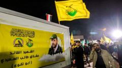 أعضاء بقوات الحشد الشعبي يسيرون خلف عربة تحمل جثمان "أبو تقوى" القائد البارز في حركة النجباء الذي قتل في غارة أمريكية