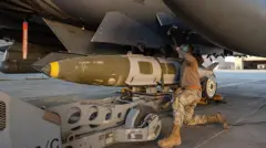 A handout from the US military shows a troop loading a missile for an attack in Syria last month