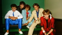 Getty Images British pop group Duran Duran wearing bright red, light blue, beige and white pastel suits in a photo studio in Tokyo, Japan in 1982.