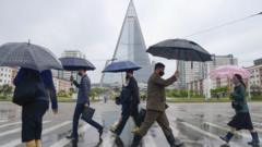 在朝鲜平壤，戴着防护口罩的人们走过路口