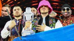 Members of the band "Kalush Orchestra" pose onstage with the winner's trophy and Ukraine's flags after winning on behalf of Ukraine the Eurovision Song contest 2022 on May 14, 2022 at the Pala Alpitour venue in Turin