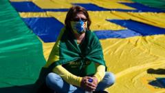 A Supporter of Brazilian President Jair Bolsonaro sits on a flag during a protest amids the coronavirus pandemic on 21 June 2020 in Brasilia.