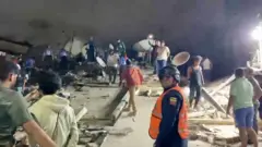 Rescuers search through rubble for earthquake survivors at a collapsed building site in Caracas, Venezuela.