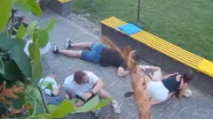 At least six people crouched on the floor as they take shelter from attack neaby