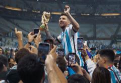 Lionel Messi dan tropi Piala Dunia.
