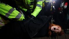 Police detain a woman as people gather at a memorial site in Clapham Common