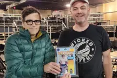 Nick handing an action figure of Weezer frontman Rivers Cuomo to him in 2023