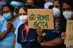 Doctors and nurses of the Lady Ridgeway Children's hospital hold placards during a silent demonstration against shortages of medicines in Colombo on April 19, 2022.