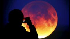 A man taking a picture of the lunar eclipse