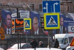 Boards with portraits of Russian President Vladimir Putin are seen on a street in Simferopol, Crimea, on March 16, 2022