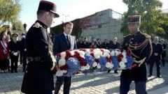 French President Emmanuel Macron lays a wreath of flowers near the Pont de Bezons