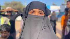 A woman wears black loose clothes by closing face except the eye