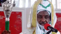 Nigeria's Kano state emir Muhammadu Sanusi dressed in a native attire and holding a staff