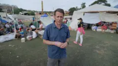 Will Grant in blue shirt in a campsite