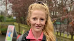 Hannah Spencer, a young woman with long hair tied in a pony tail, smiles in a local park