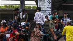 People gather in front of the department of Immigration and Emigration to apply for a passport in Colombo on 18 July 2022. - One of the longest queues in the Sri Lankan capital Colombo is for the exit, as thousands of people line up outside the immigration office seeking passports to escape the country's economic crisis