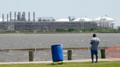 A man stares across the bay from the vast Sabine Pass LNG export terminal, the world's largest