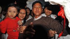 Myanmar political prisoner Kyaw Min Yu (C), known as Jimmy, and his wife Ni Lar Thein (L) holding her child, both members of the 88 Generation student group, celebrate upon their arrival at Yangon international airport following their release from detention on January 13, 2012.