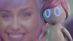Imagem de personagem interpretada por Miley Cyrus aparece em tela e, na frente, a robô Ashley