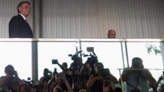 Bolsonaro em andar de cima caminhando, e no reflexo abaixo dele, aparecem jornalistas e fotógrafos