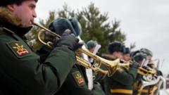 Russian servicemen play brass instruments during a funeral