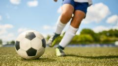 childs-legs-kicking-football