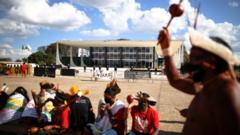 Indígenas em frente ao prédio do Supremo durante um dia, um deles levantando um objeto