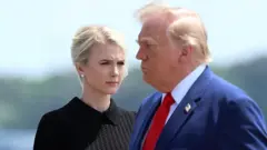 Natalie Harp, executive assistant to US President Donald Trump, stands as President Trump arrives for a dignified transfer.