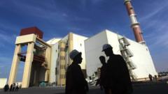 Two people outside Iran’s Bushehr nuclear power plant